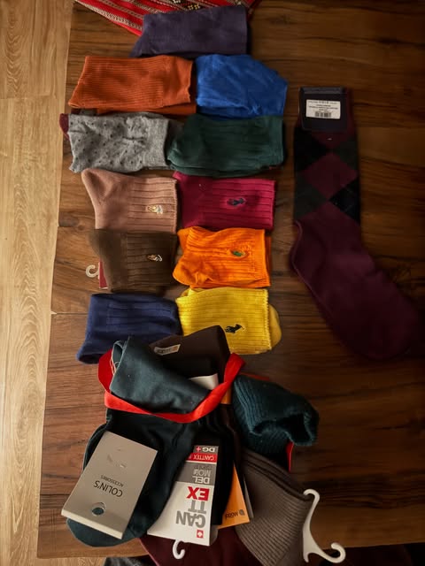 Rows of colorful men’s dress socks laid out on wood