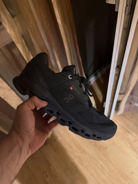 Black On running shoe held in the hand