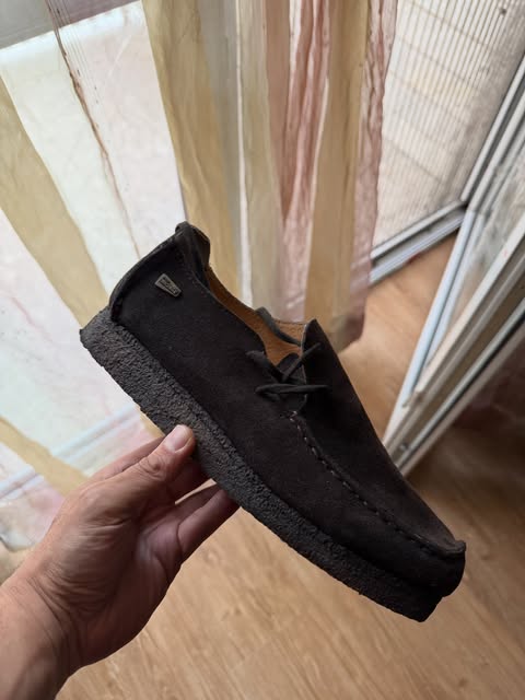 Dark brown suede wallabee-style shoe with a crepe sole
