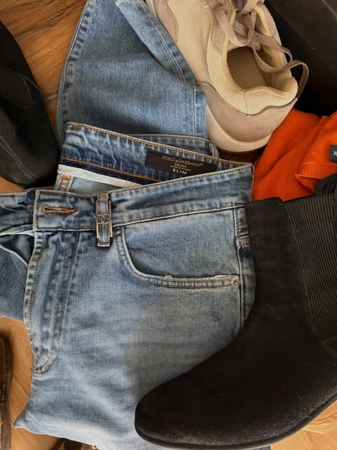 Light-wash jeans beside a beige sneaker and a black Chelsea boot